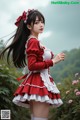 A woman in a red and white dress is posing for a picture.