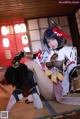 A woman in a cosplay outfit sitting on the floor.