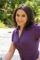 A woman in a purple shirt posing for a picture.