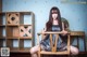 A woman sitting on a wooden chair in a room.