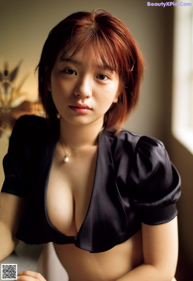 A woman in a black top is posing for a picture.