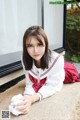 A woman in a school uniform laying on the ground.