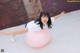 A woman is sitting on a pink exercise ball.