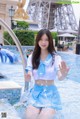 A woman in a blue and white outfit standing in a pool.