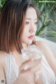 A woman holding a glass of water in her hand.