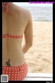 A woman in a bikini with a tattoo on her back.