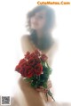 A woman holding a bunch of red roses in her hands.