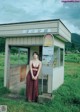 A woman standing in front of a small building.