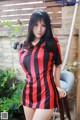 A woman in a red and black striped shirt posing for a picture.