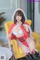 a woman in a santa claus outfit sitting on a yellow chair