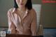 A woman in a pink shirt sitting at a desk.